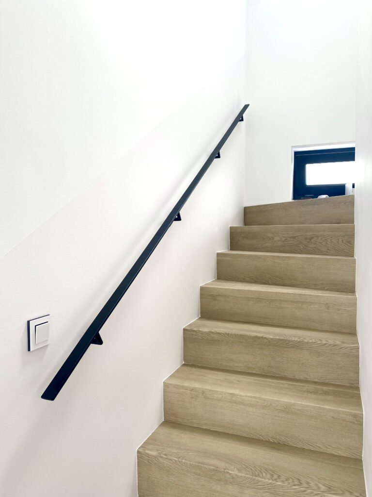 Černé madlo u schodiště z kvalitní oceli.