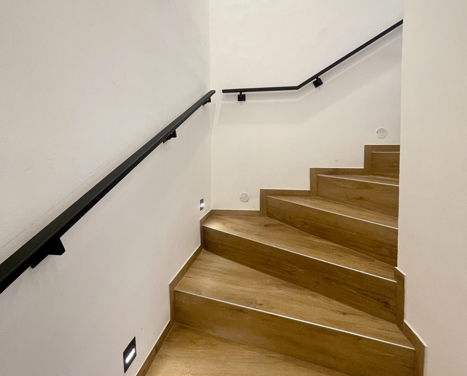 Kovové madlo na schodišti v rodinném domě.