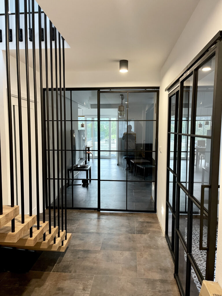 Industriální kovové dveře Hardsteel v interiéru mezi chodbou a obývacím pokojem