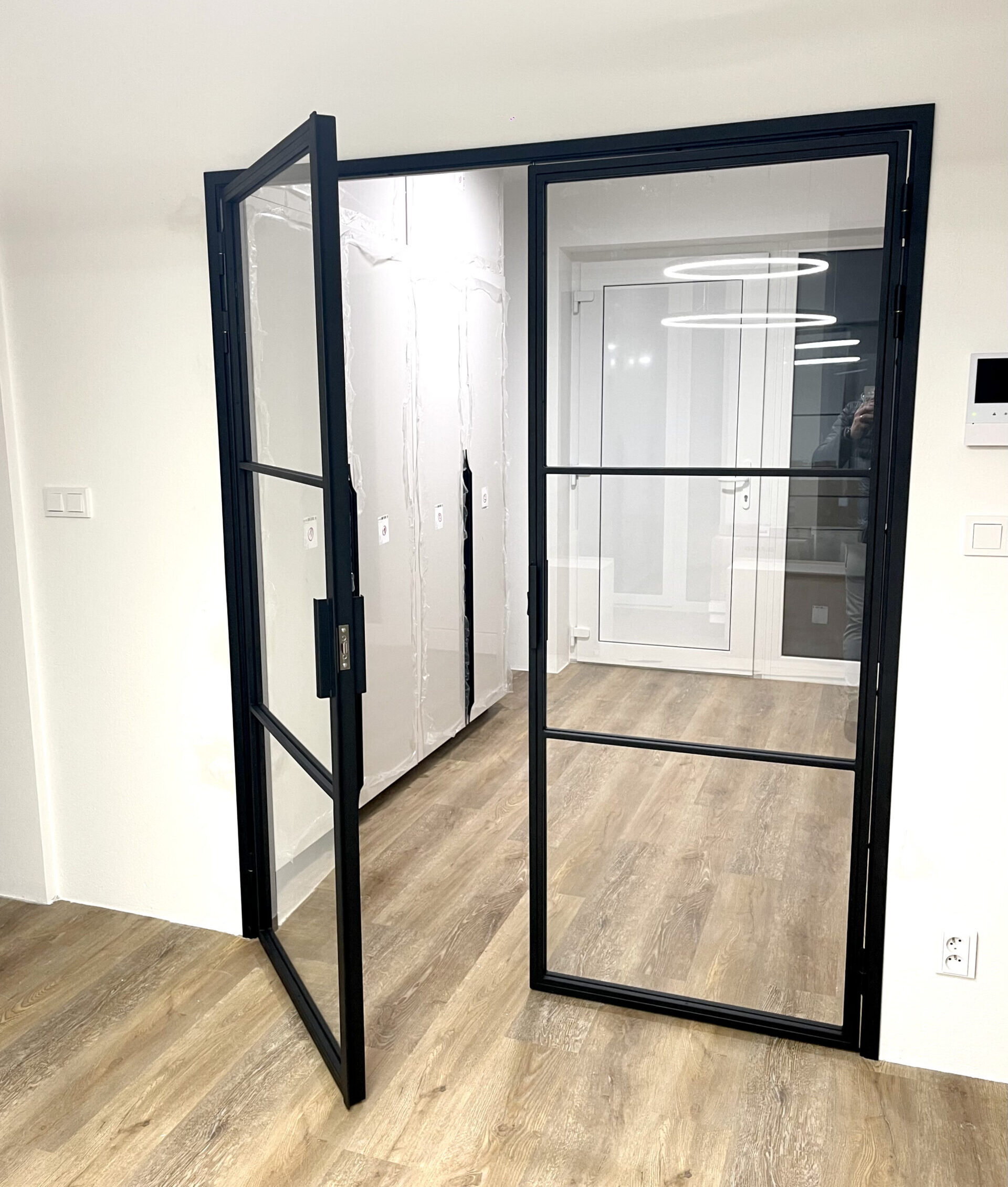 Industriální kovové dveře se skleněnou výplní v interiéru